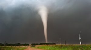 A tornado touching down in Kansas. Wind turbines are visible.
