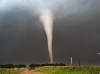 A tornado touching down in Kansas. Wind turbines are visible.