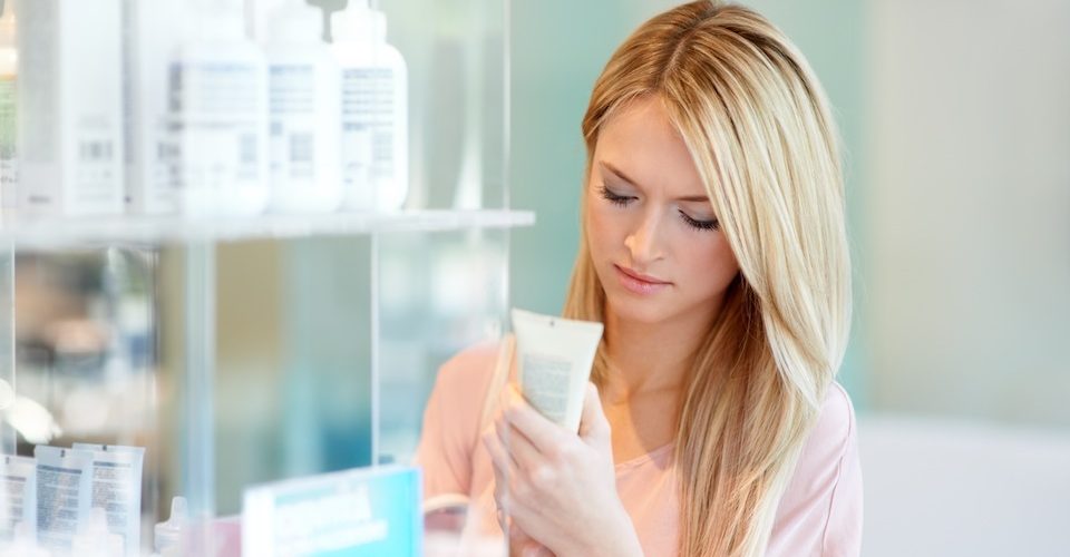 Woman checking for toxic ingredients in beauty products. Alternatives Journal.