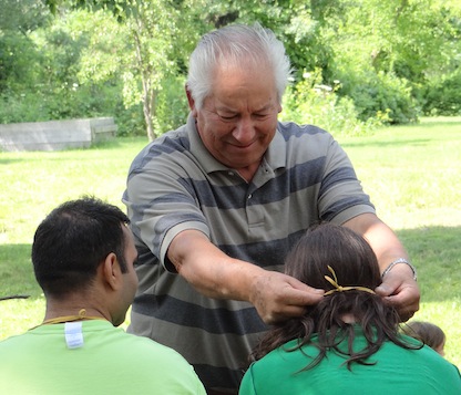 Elder Eddie Gray puts medicine pouch on Harry Benedict on the Otesha Nation to Nation Tour