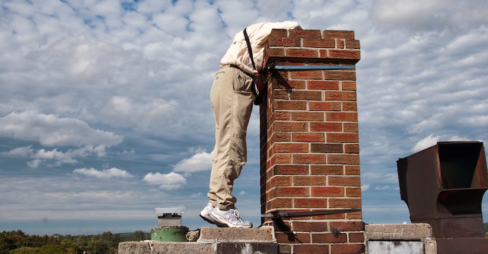 An Ontario SwiftWatch volunteer peers into a chimney.