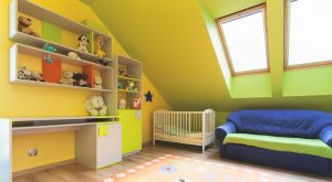 Nursery with shelves, a crib, couch and skylights.