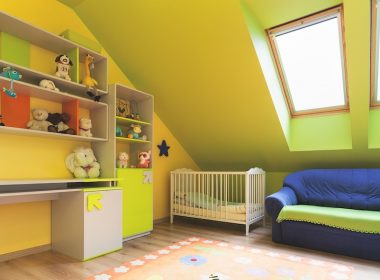 Nursery with shelves, a crib, couch and skylights.