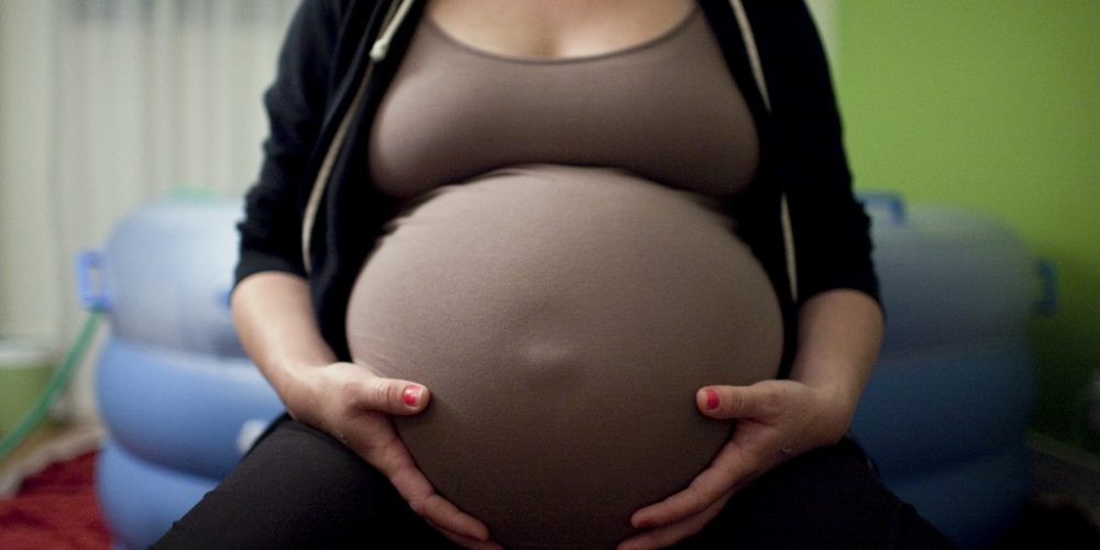 Pregnant woman in front of a birthing pool.