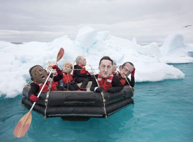 Activists in papier-mâché world leaders' heads flounder in the Arctic Ocean.