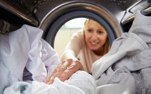 (Photo: a woman reaching into a washing machine)