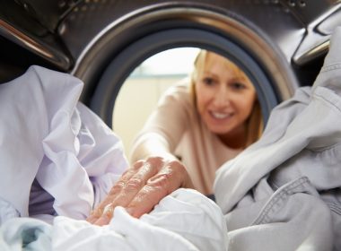 (Photo: a woman reaching into a washing machine)