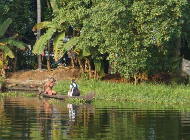 A man paddles a girl to school on the backwaters of Kerala, India