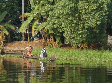 A man paddles a girl to school on the backwaters of Kerala, India