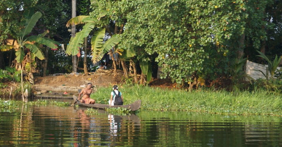 A man paddles a girl to school on the backwaters of Kerala, India