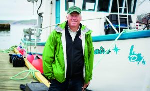 David Miller stands on the dock near a fishing boat